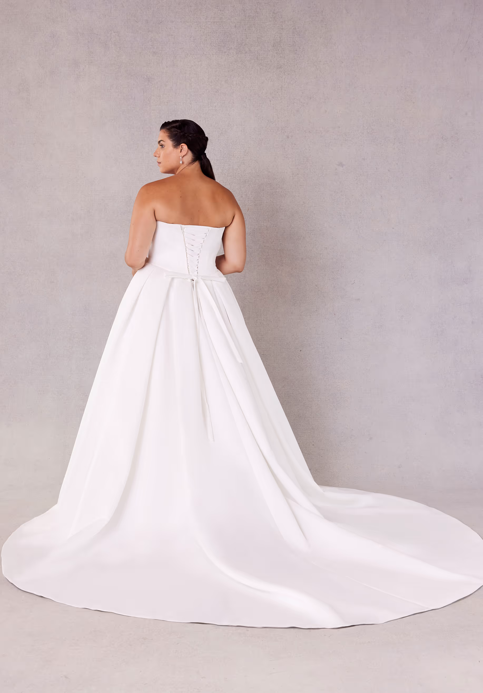 Timeless ball gown wedding dress has a sweetheart corset bodice with beaded, draped bust on a basque waist with lace-up corset back, detachable off-the-shoulder sleeves, and side bustles on a box-pleated satin skirt.