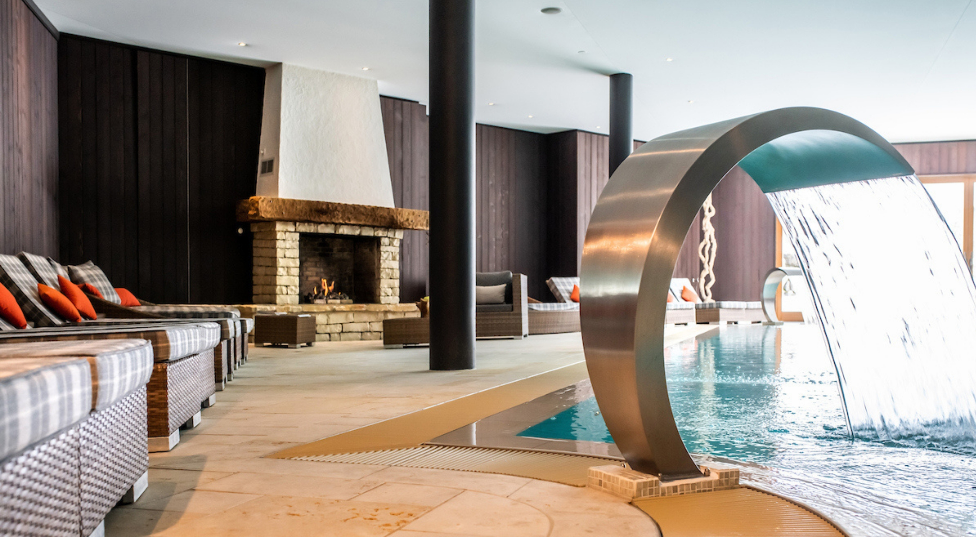 Photo of the spa area inside the Chalet RoyAlp hotel in Villars-sur-Ollon, with swimming pool and fireplace.