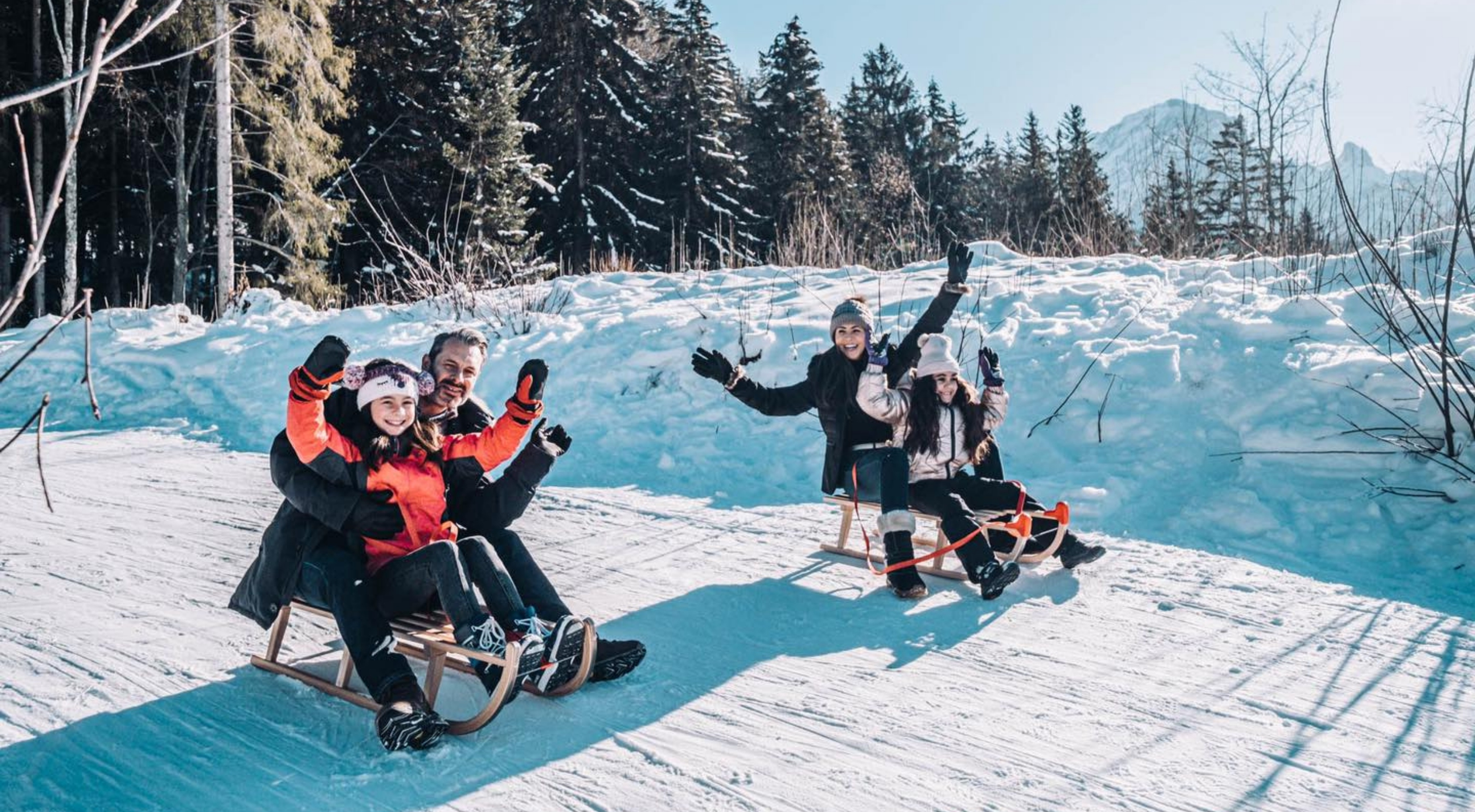 A family enjoys time together sledging in the Swiss Alps