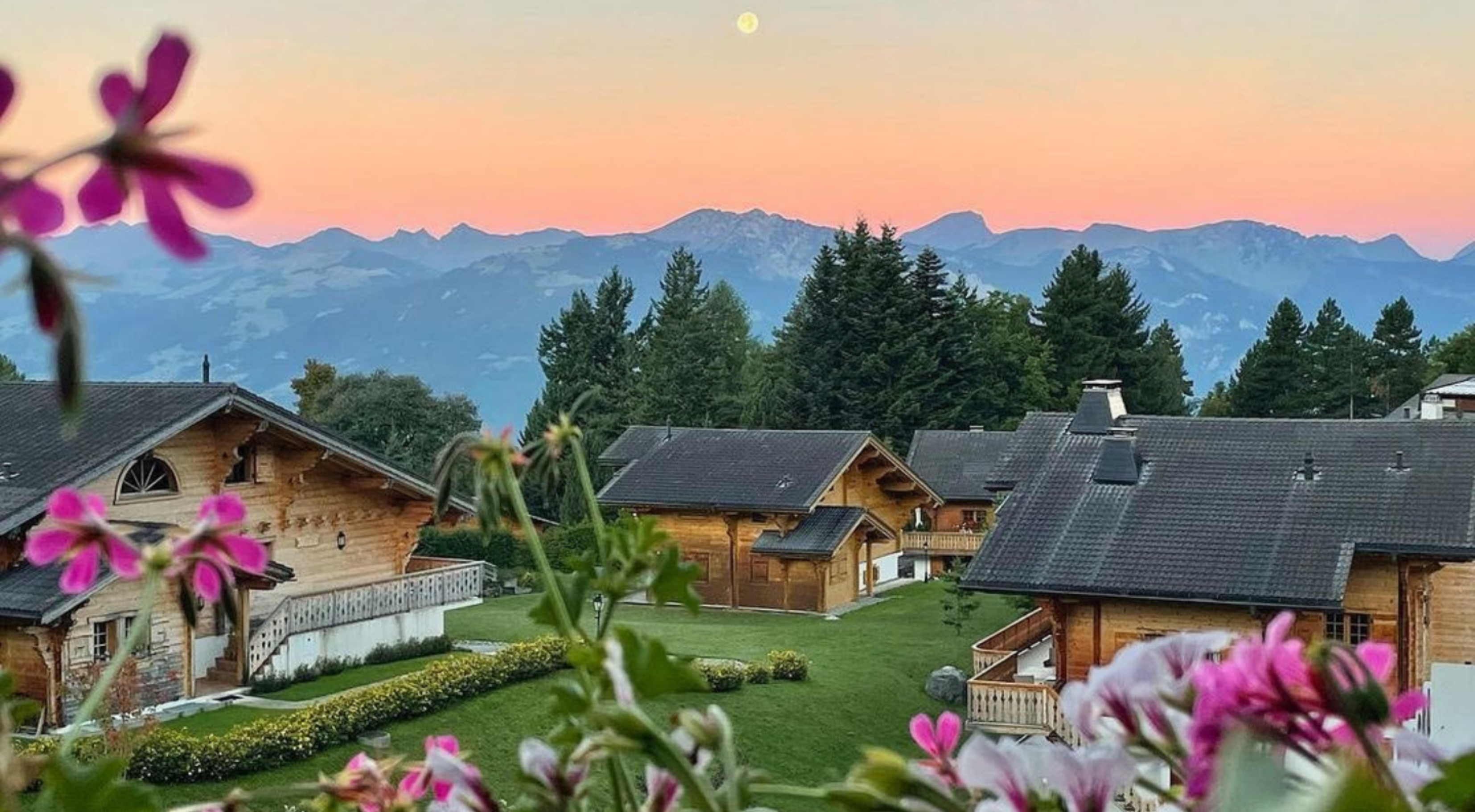 Photo of the chalets for rent in the Chalet RoyAlp hotel, with a lovely view of the Swiss Alps at sunset.