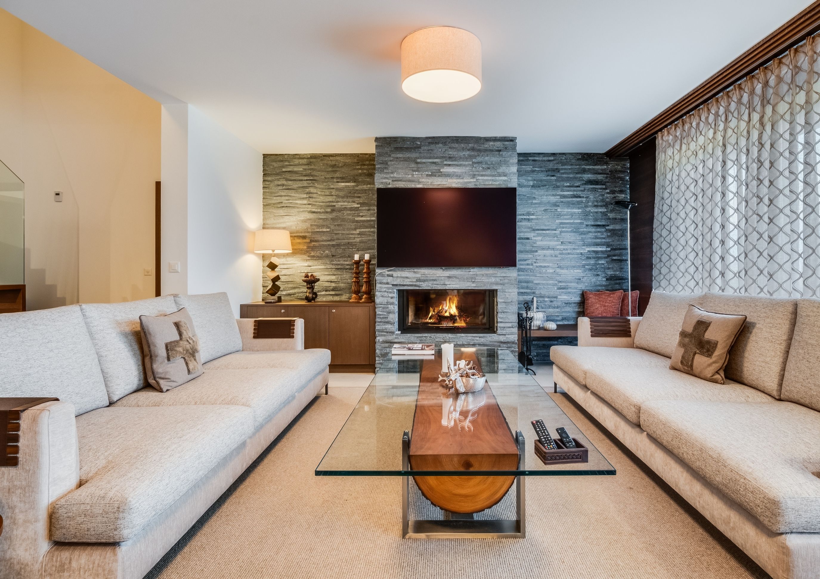 Photo of the large, luxurious living room with mountain views, featuring sofas, armchairs, and artwork, located in the Chalet RoyAlp hotel in Villars-sur-Ollon.