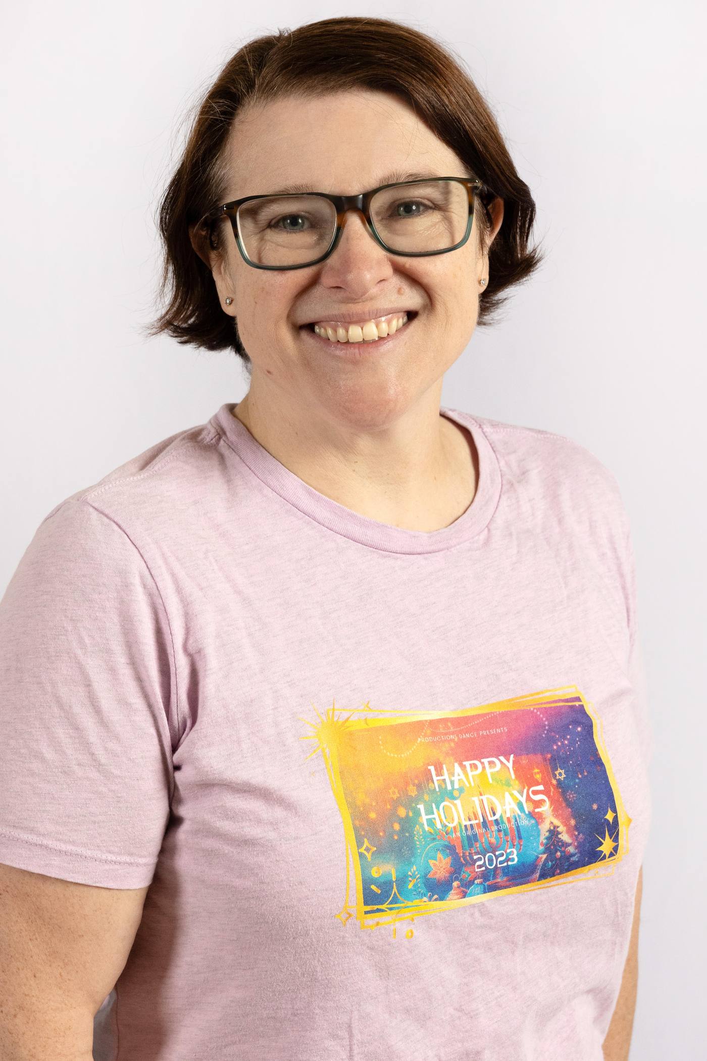 Mama Seana, Productions Dance family coordinator, smiling in a studio portrait against a pale grey background.
