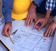 Three people pointing and discussing a detailed blueprint on a table.