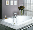 Bathroom sink with silver faucet, soap dispenser, flower vase, and three small framed pictures on a wall.