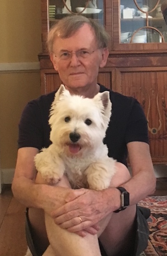 Photo of a man with a West Highland Terrier dog sitting in his lap