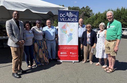 Photo of 8 people with a DC Villages banner