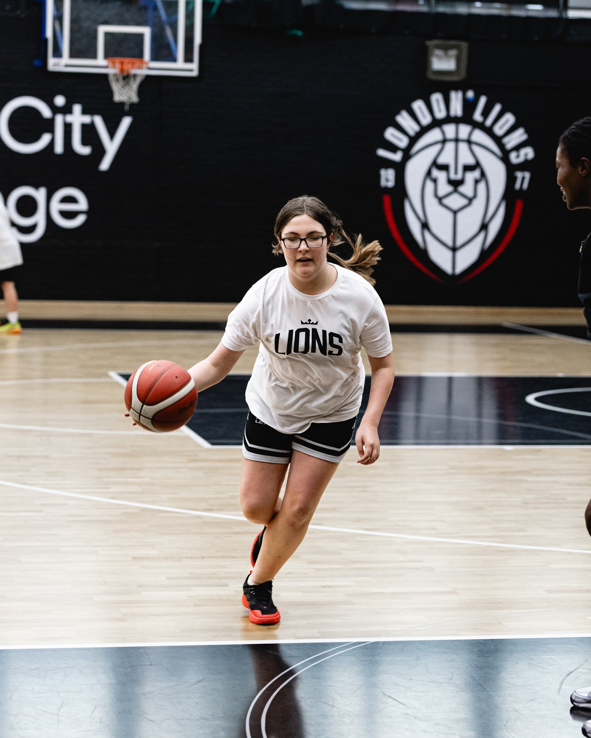 Girl playing basketball at a London Lions camp
