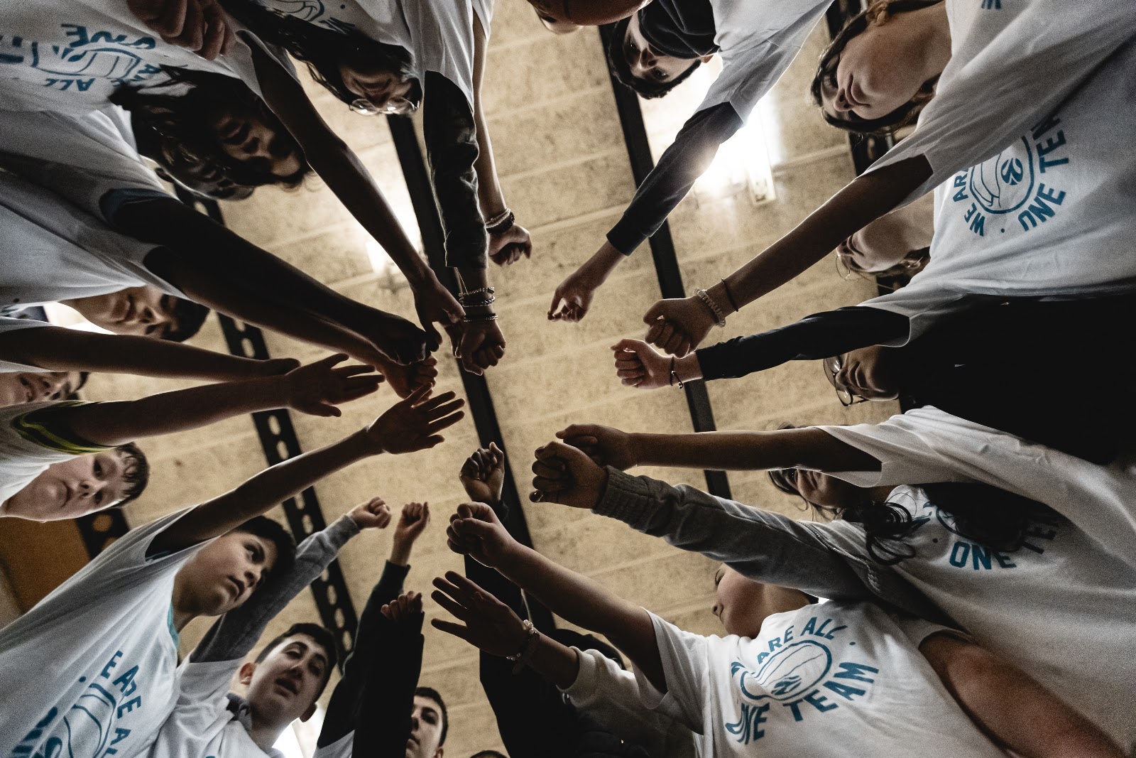 Players and coaches putting their hands in together at the end of a session
