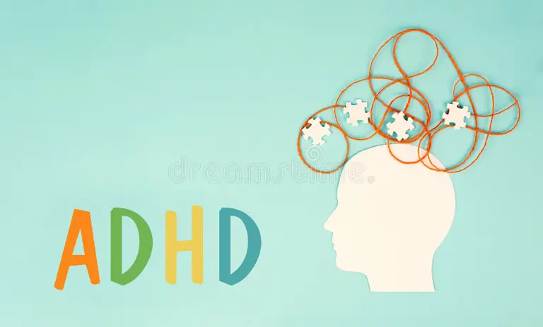 Silhouette of a head with tangled orange lines and puzzle pieces representing ADHD concept on a turquoise background.