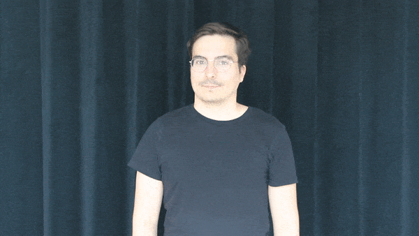 A GIF of a man with glasses, black hair and in black t-shirt doing a shrug expression.