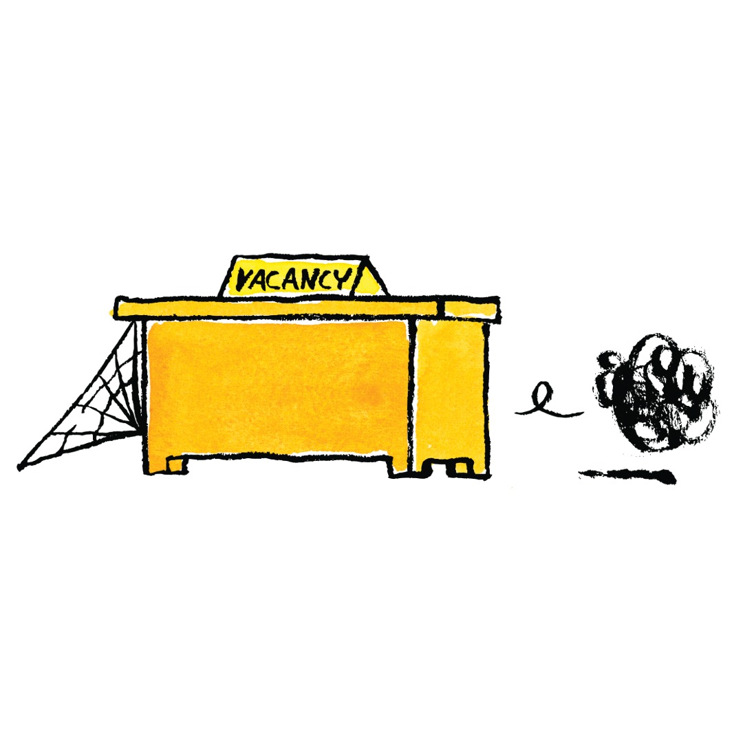 Illustration of an empty yellow desk with a 'VACANCY' sign on top and cobwebs underneath, symbolizing a long-unfilled position. To the right, a scribbled, faceless figure rolls by, representing fake or unqualified job applicants failing to fill the role.