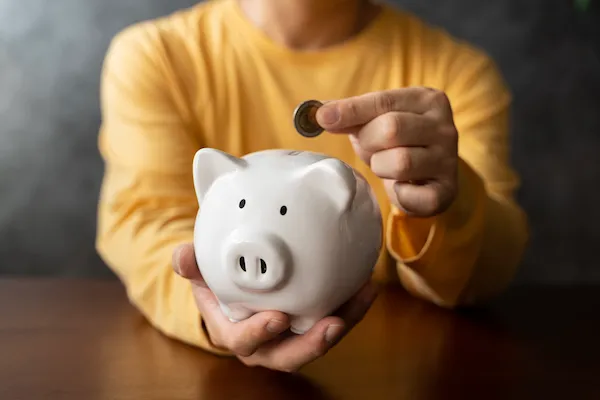 imagem principal homem guardando dinheiro que economizou no cofre