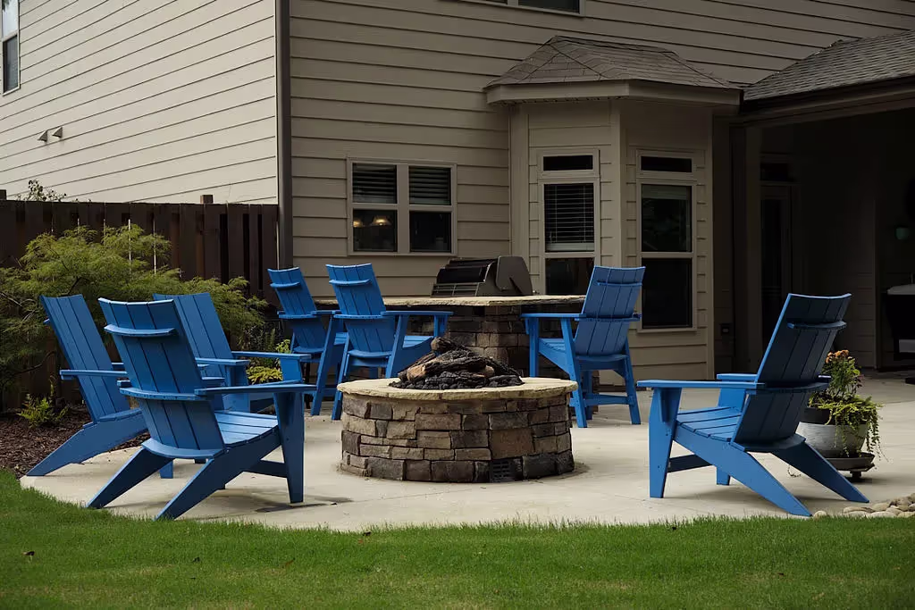 outdoor fireplace with blue chairs around it