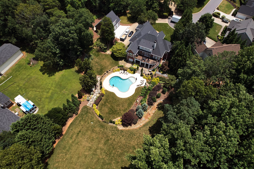 Landscape design plans being reviewed by a designer with client outdoors in Greenville, SC