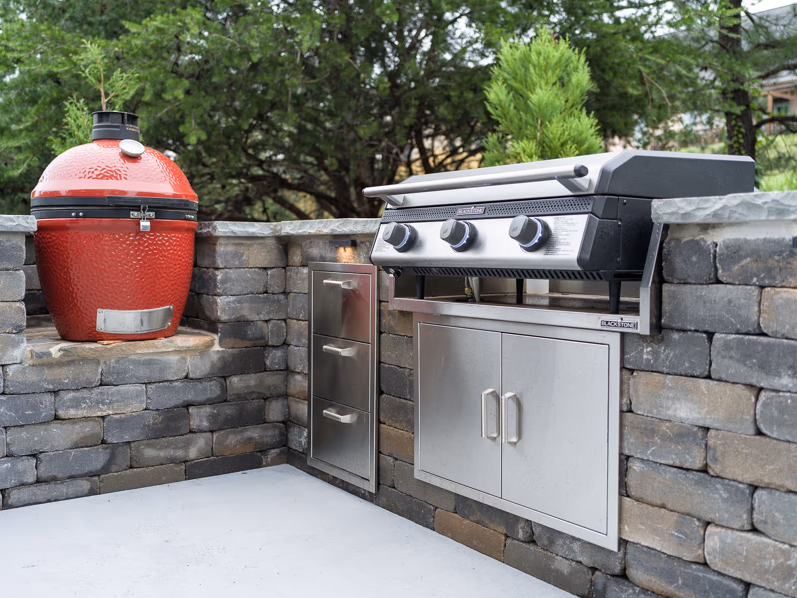 Luxury outdoor kitchen with grill, bar seating, and stone finishes in a Greenville backyard