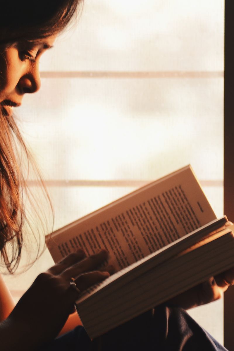 Una mujer de perfil leyendo un libro.