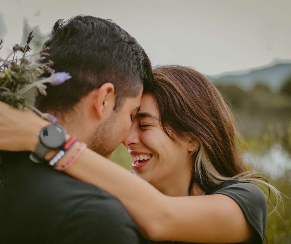 Pareja abrazada sonriendo.