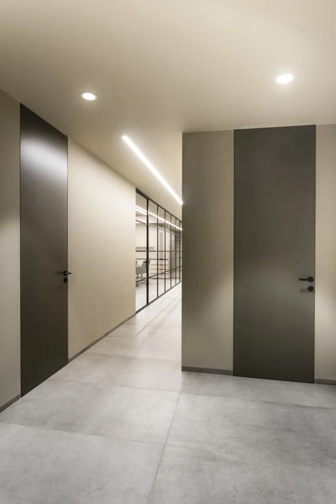 Fortius full-height flush-to-the-wall door with a concealed door jamb in an office space. Linus flush baseboard.