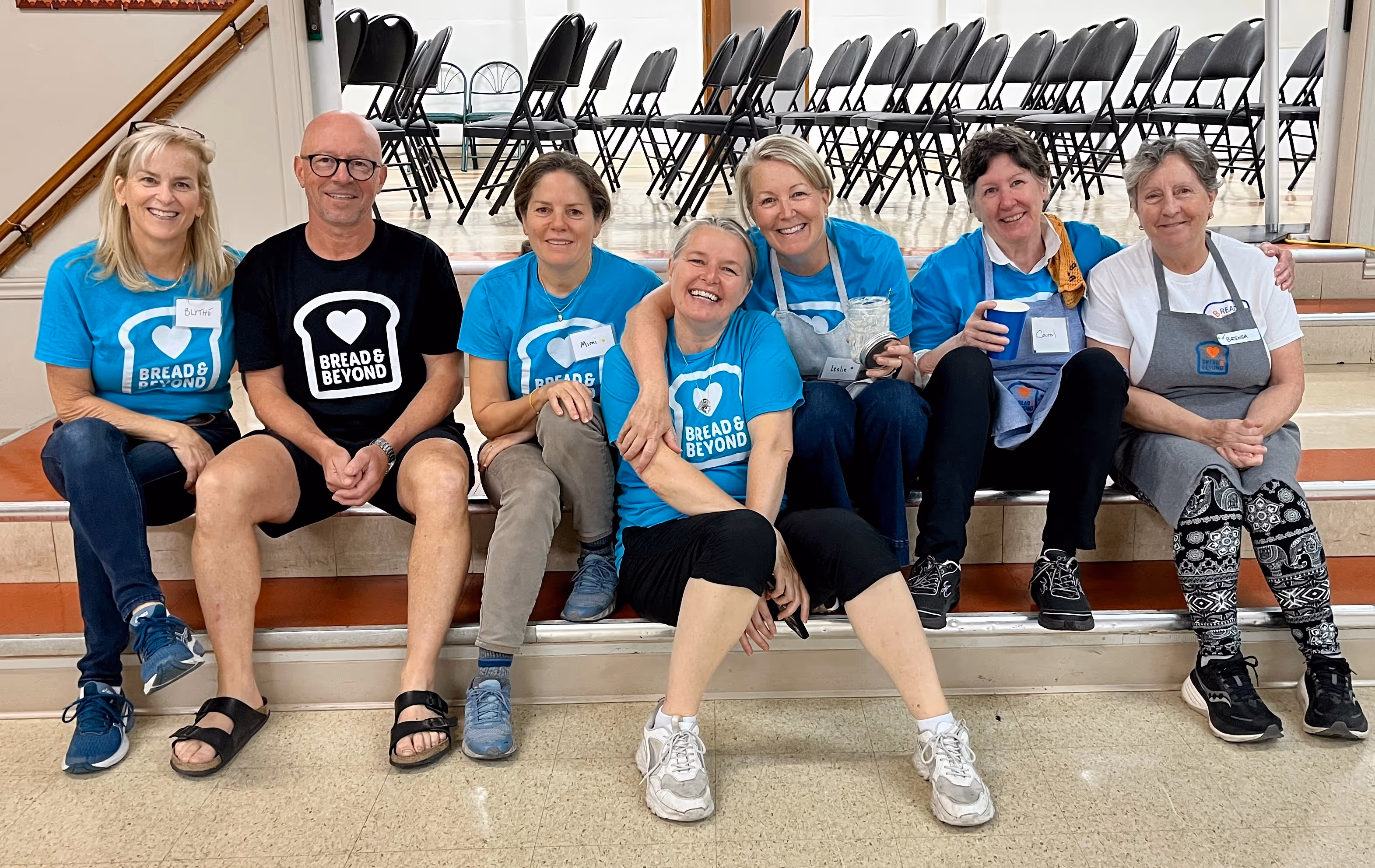 people smiling next to car trunk