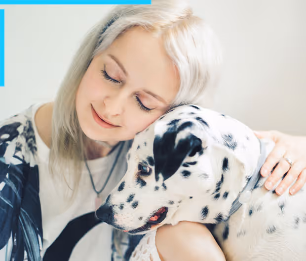 A girl gently holding her dog with closed eyes