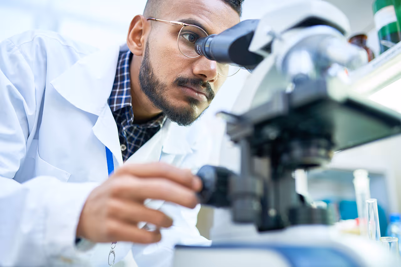 A young scientist looking through a microscope