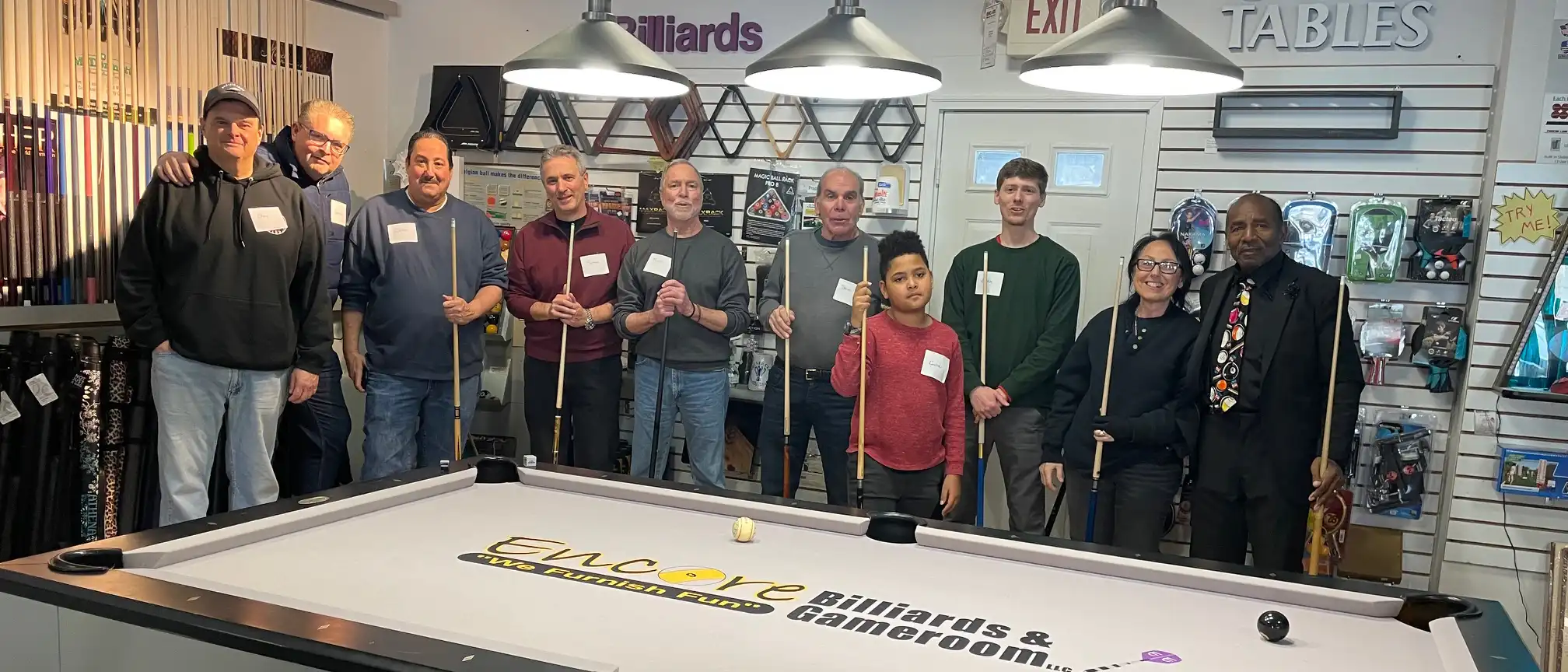 
Gemini said
A diverse group of pool players pose with cues around a modern table at Encore Billiards, a local game room company offering billiards education.