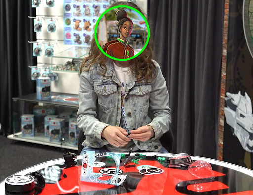 Photo of a young girl assembling a Temari mech with the parts and open packaging on a table in front of her. Her face is blurred out to protect her identity.