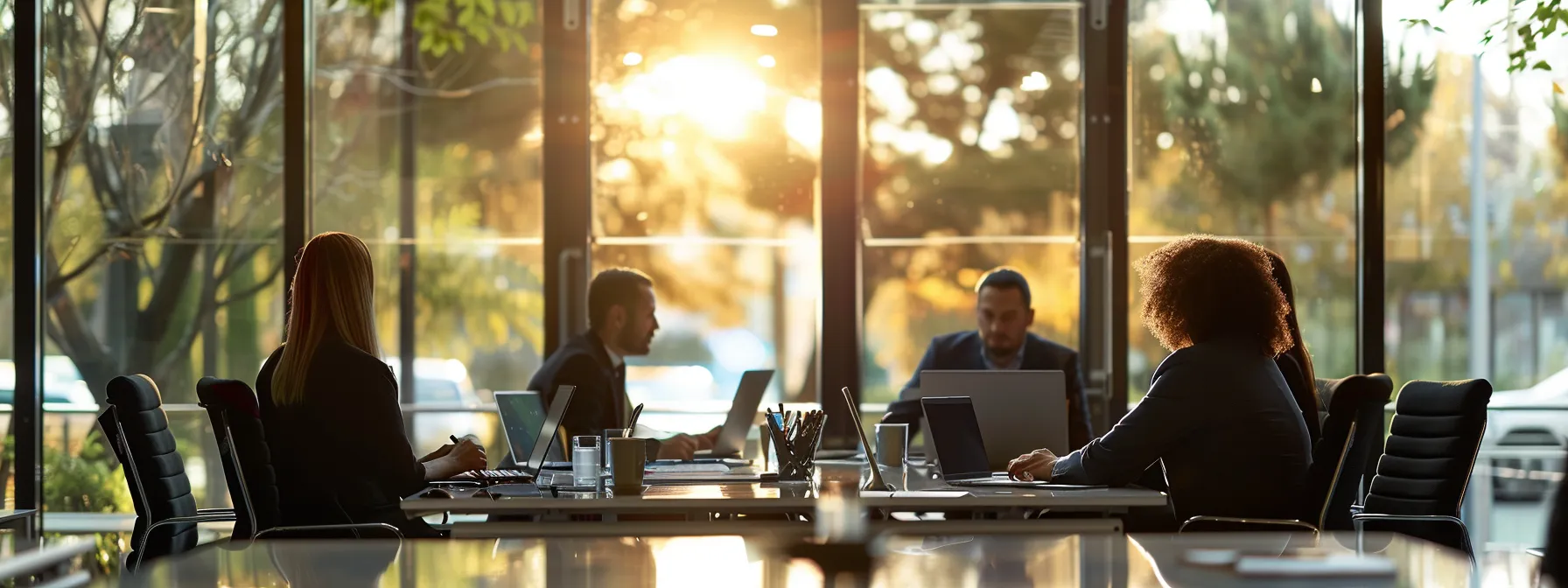 group of professionals in a boardroom analyzing data on laptops and discussing legal strategy for car accident cases in reno.