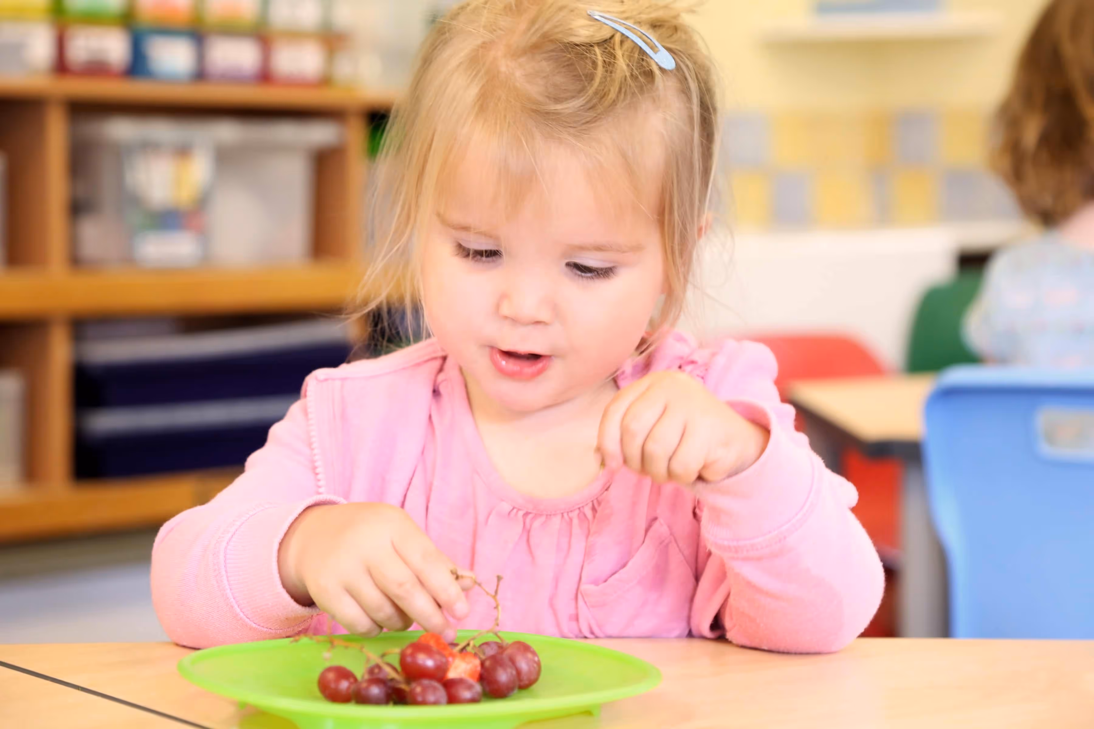 Little girl eating grapes