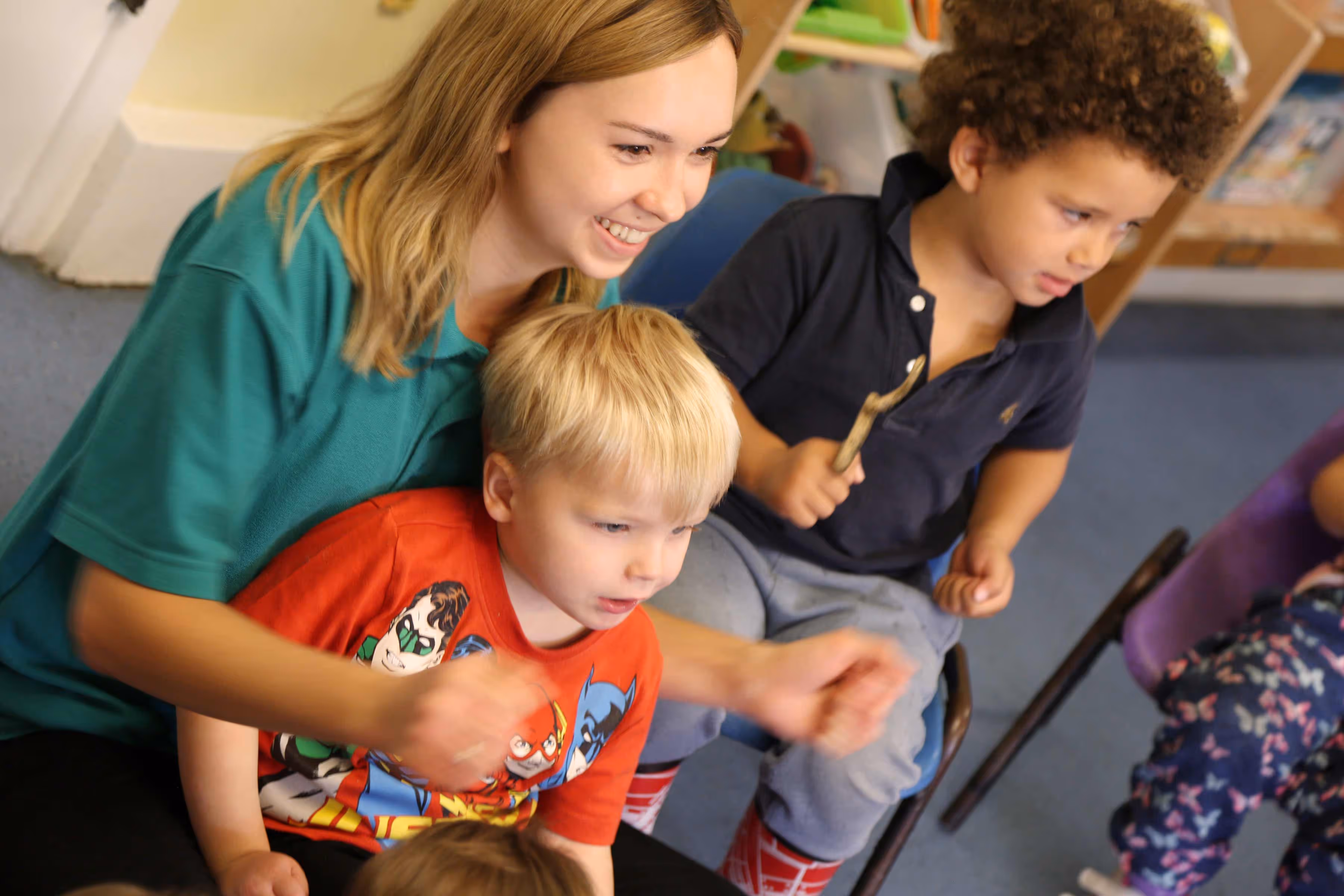 Teacher cuddling young boy playing a game