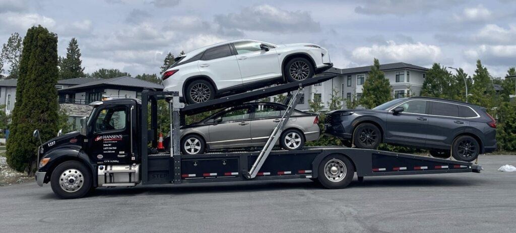 A 3-car wedge truck delivering a vehicle shipment to a residence.