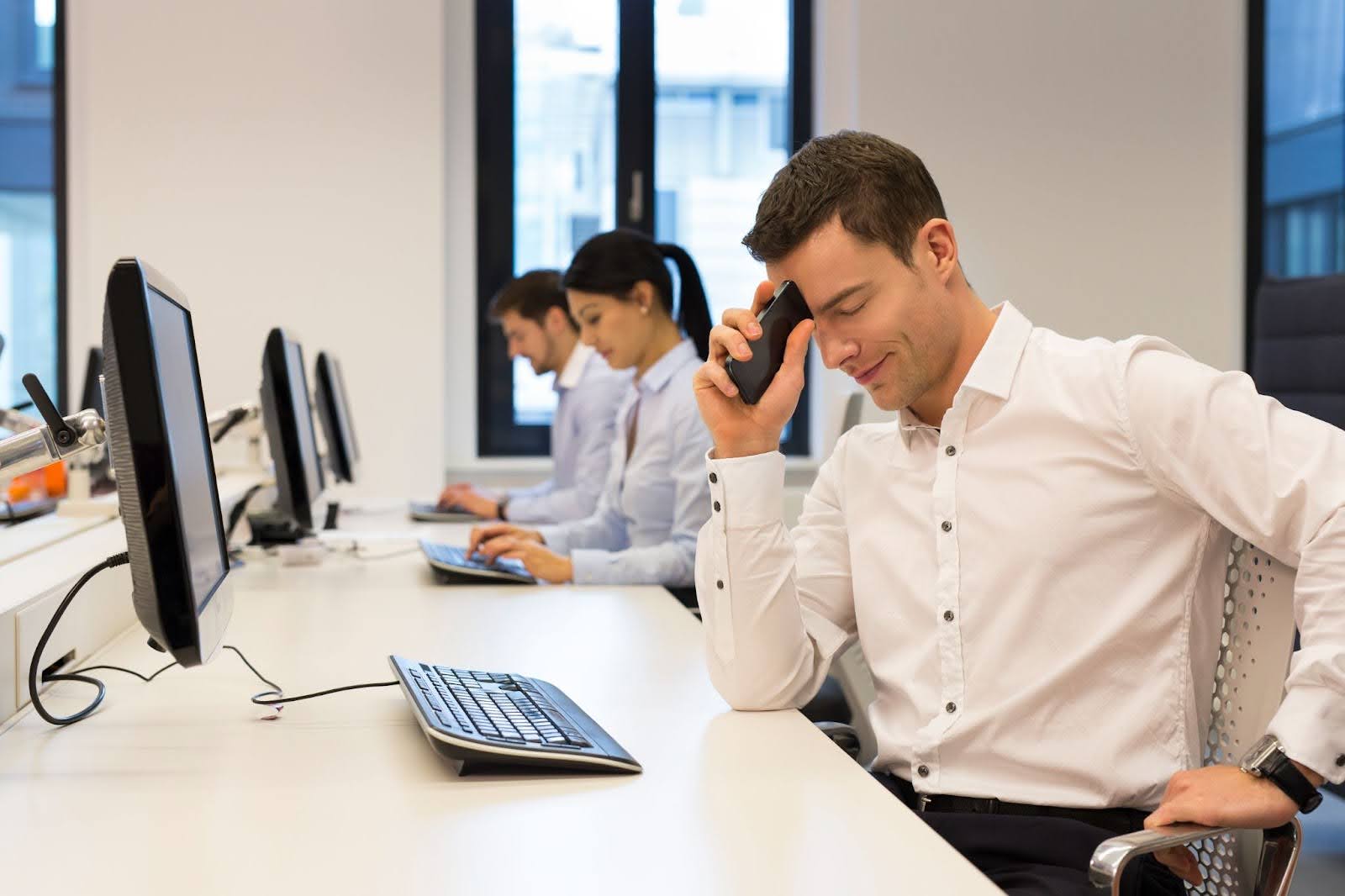 Sales agent with negative expression sitting at office