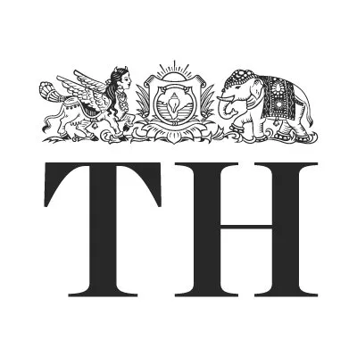 Black and white emblem with a winged lion on the left, an ornate shield in the center, and an elephant adorned with a decorative cloth on the right above large letters 'TH'.