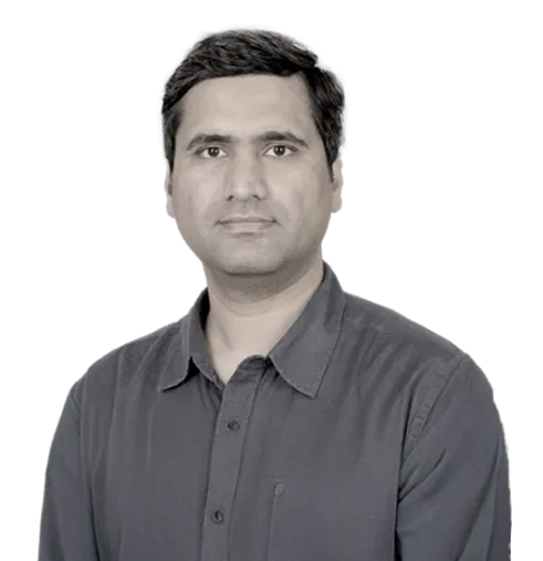 Portrait of a man with short black hair wearing a dark gray buttoned shirt against a transparent background.
