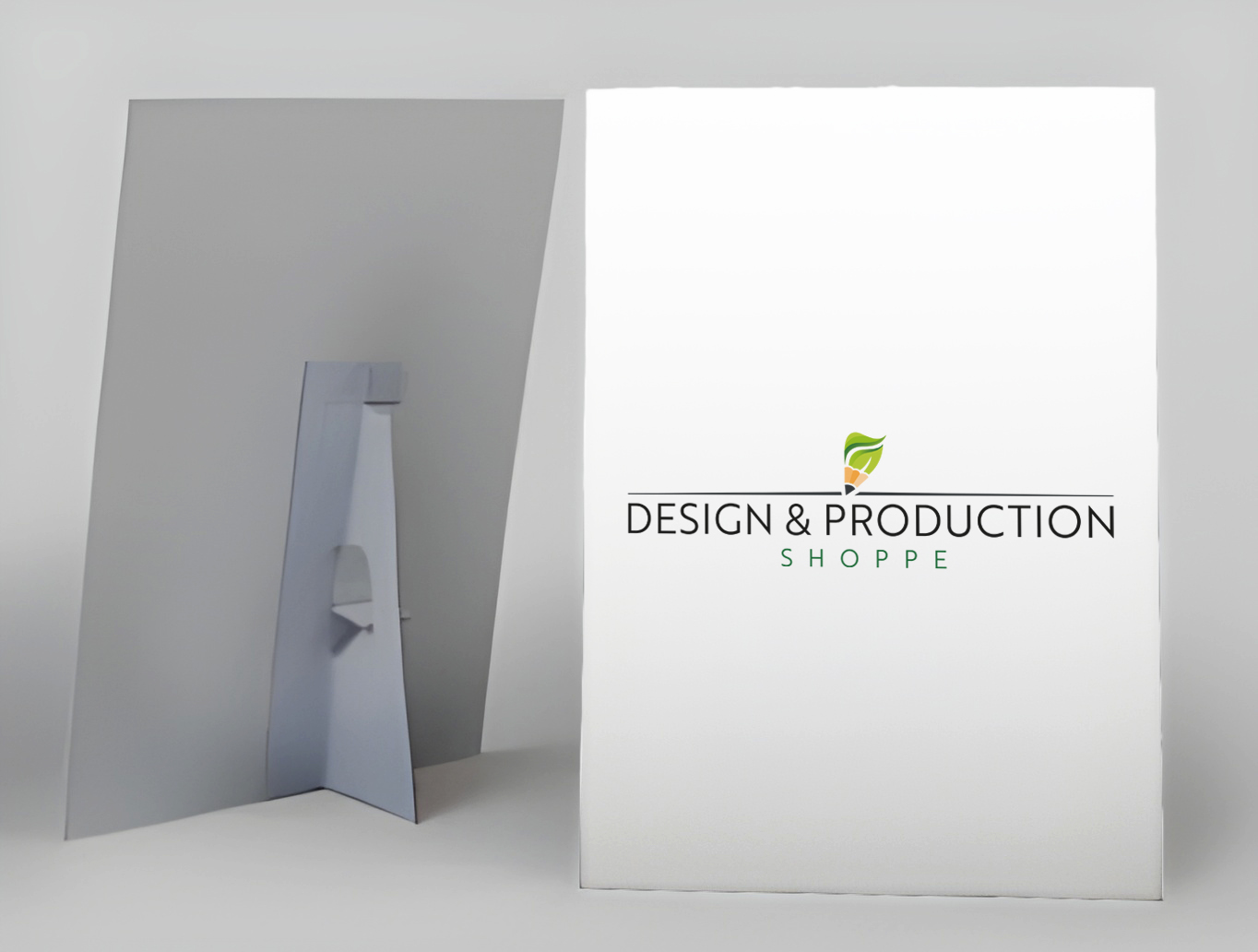 White strut card featuring a logo with a green leaf and pencil above the text 'Design & Production Shoppe.'