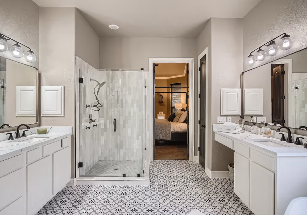Spacious primary bathroom with double vanities, separate tub and shower, and modern finishes.