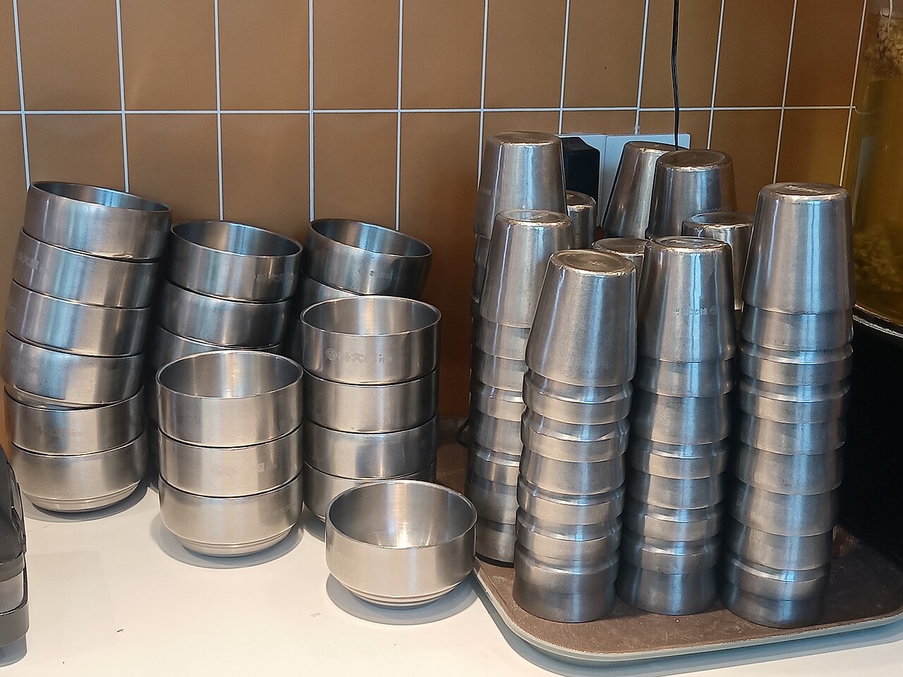 Stainless steel bowls stacked in a commercial kitchen, the everyday equipment a service company keeps running