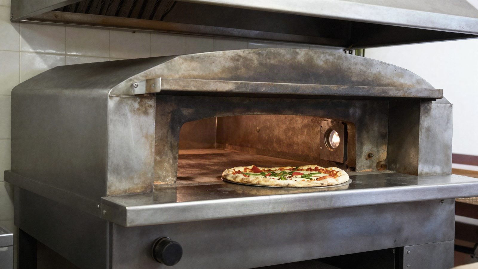 A commercial deck pizza oven in a restaurant kitchen
