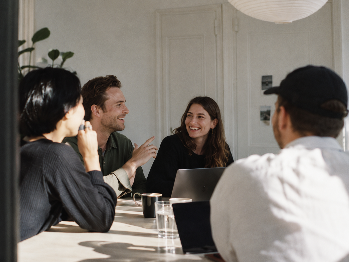 Sales team talking around a table with laptops