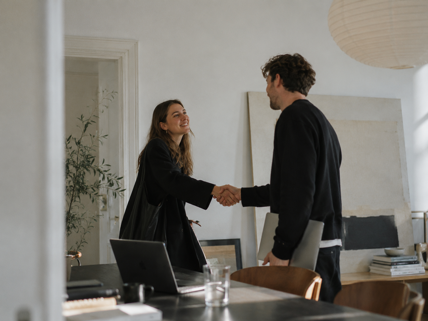 Two partners shaking hands in a meeting room