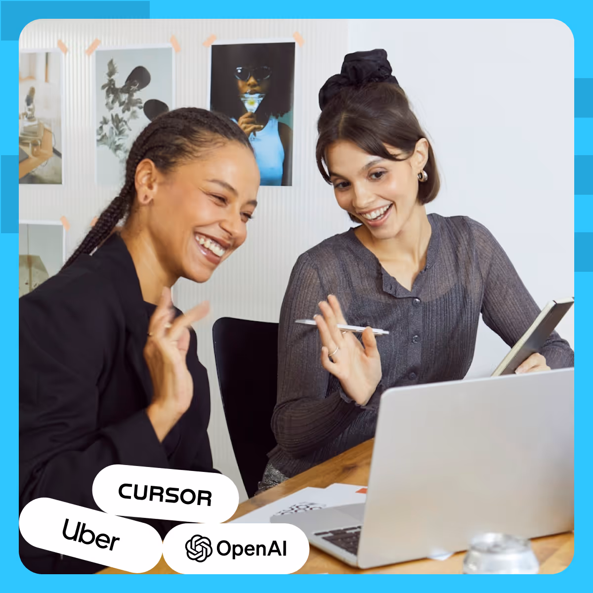 Two women sitting in front of a laptop smiling