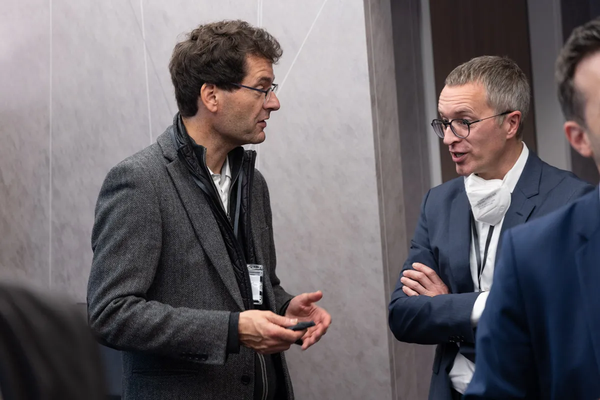 2 Männer im Anzug diskutieren