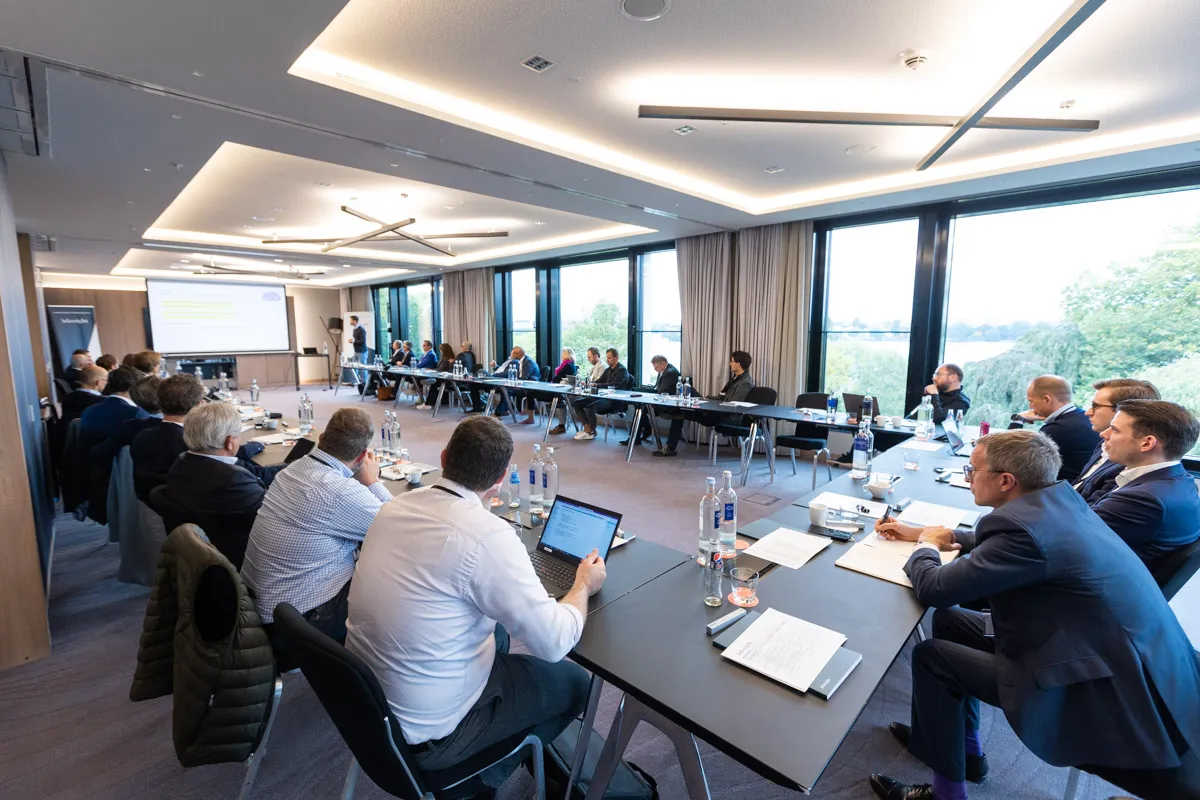 Seitenansicht von Menschen in einem Meeting am großen Tisch