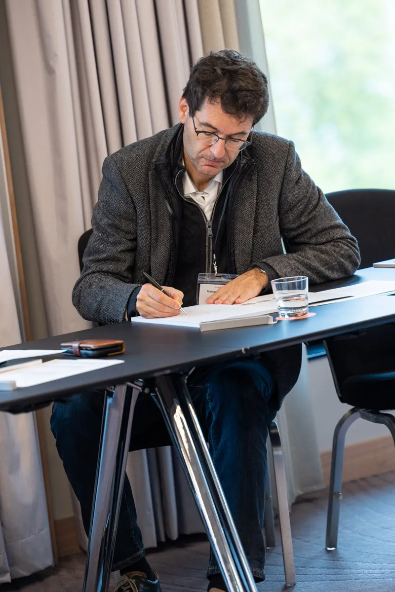 Mann macht Notizen auf ein Blatt Papier