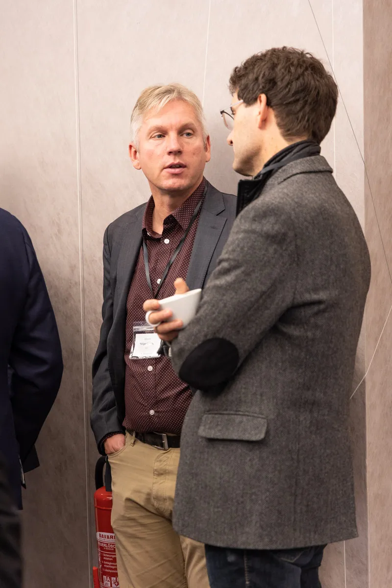2 Männer unterhalten sich in Meetingpause