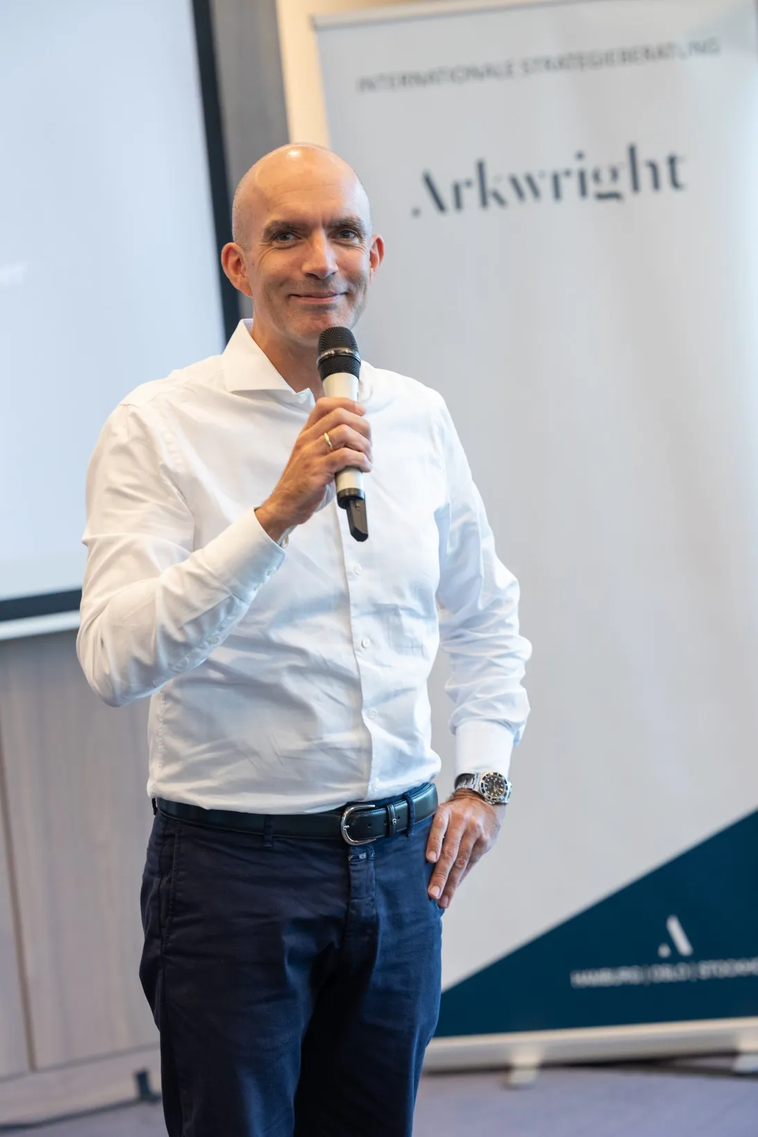 Mann in weißem Hemd spricht in ein Mikrofon