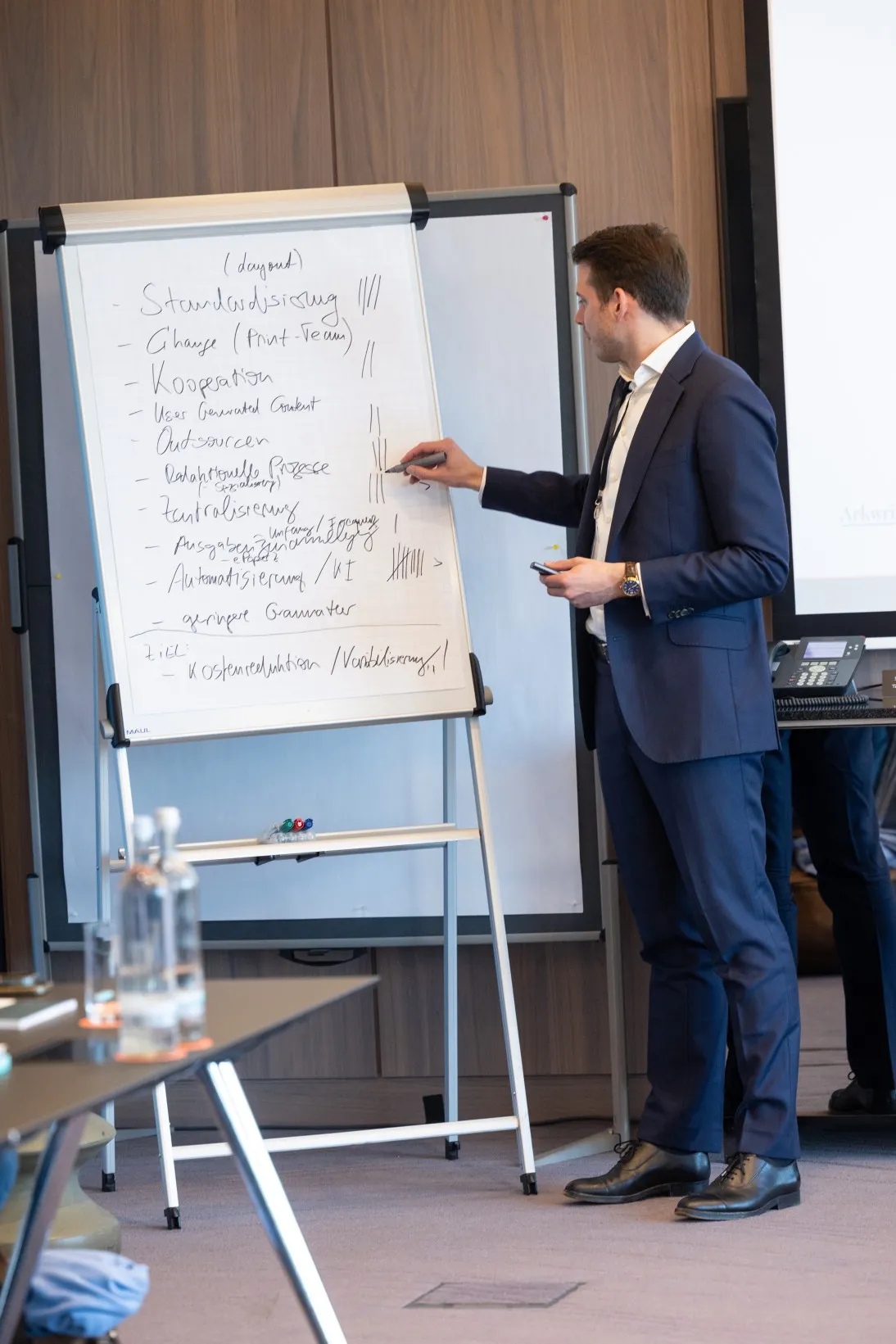 Mann schreibt Infos auf ein Flipchart
