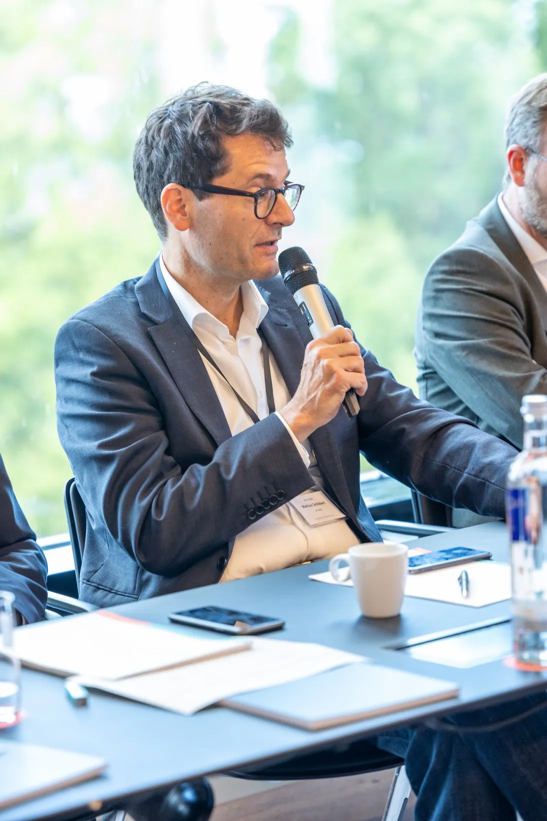 Menschen an einem Konferenztisch diskutieren und sprechen in ein Mikrofon