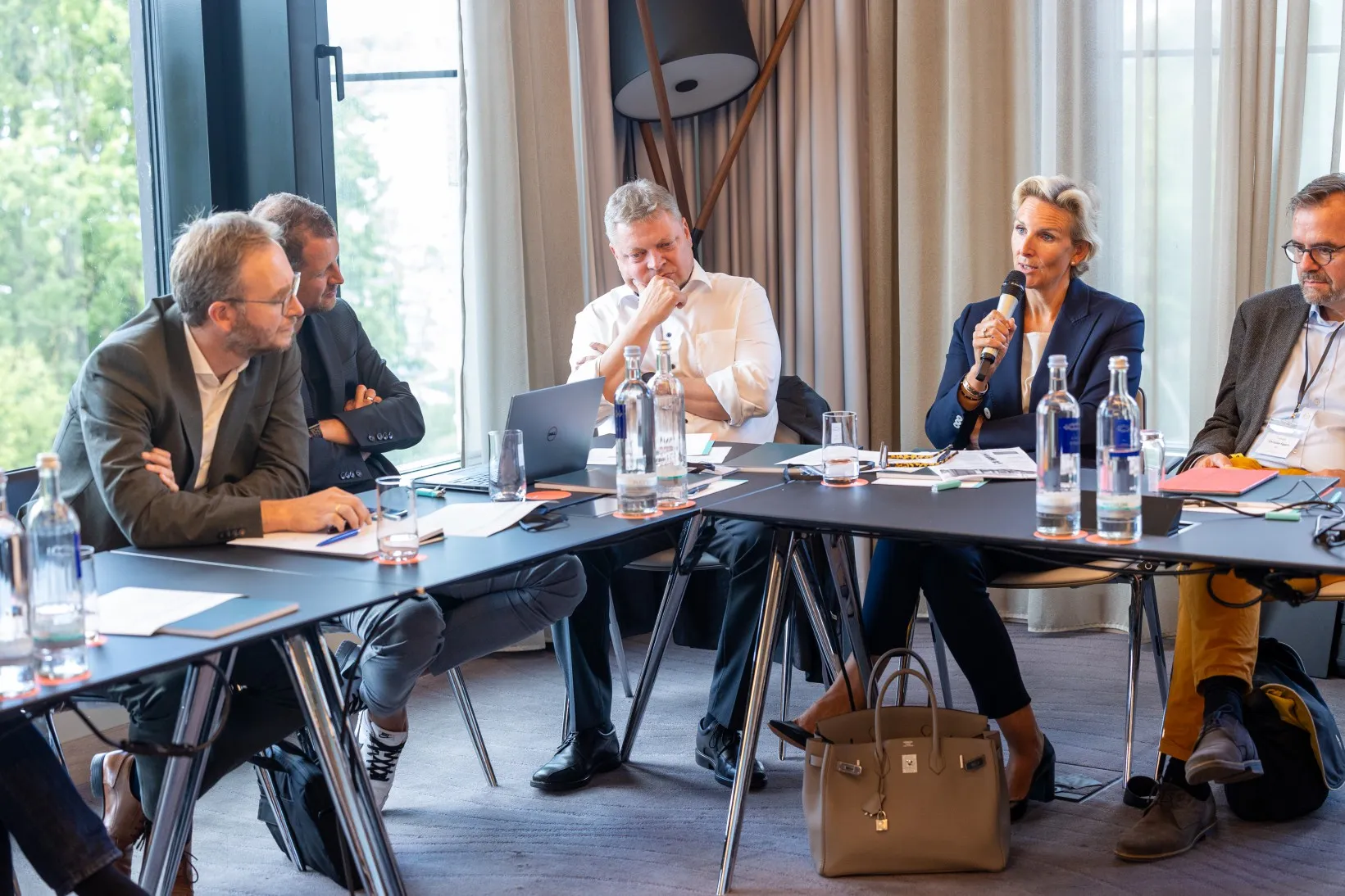 Menschen an einem Konferenztisch diskutieren und sprechen in ein Mikrofon