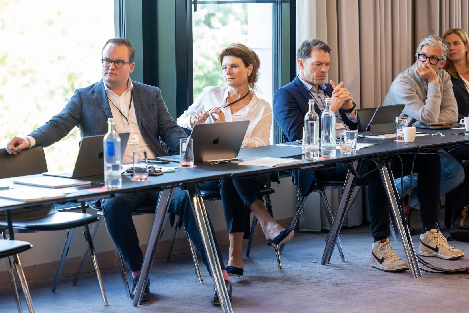 Männer und Frauen lauschen einem Vortrag in einem Konferenzraum